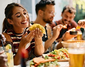 Woman smiling while eating lunch with friends at restaurant