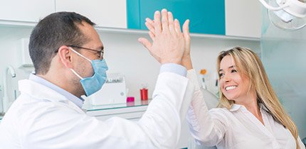 Smiling patient gives person high five