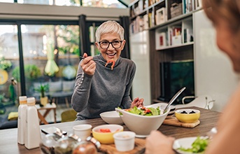 Woman smiling while eating lunch with friend