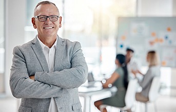 Businessman with glasses smiling in office