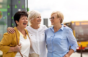 Three women smiling outside